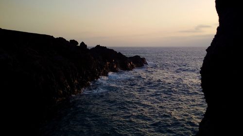 Rock formations in sea against sky during sunset at canary islands