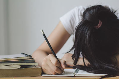 Midsection of woman reading book on table