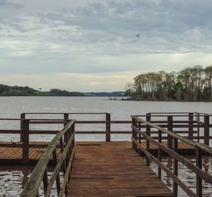 Empty wooden pier on lake against sky