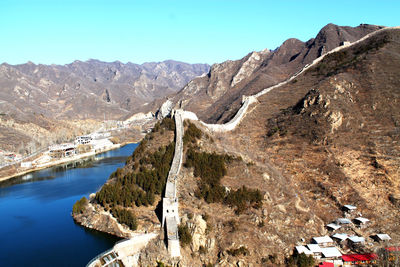 Scenic view of mountain range with the great wall of china against sky