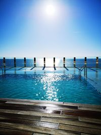 Wooden posts in swimming pool against clear sky