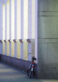 Bicycle leaning on wall of building