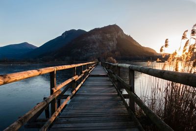 Pier over lake against clear sky