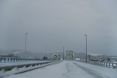 View of snow covered road against cloudy sky