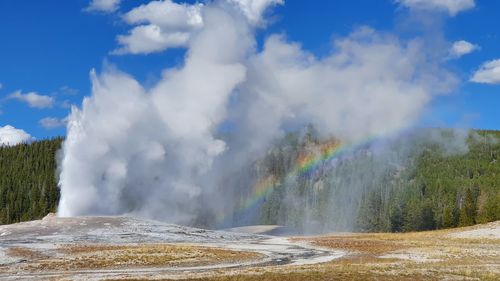 Panoramic view of rainbow over landscape against sky