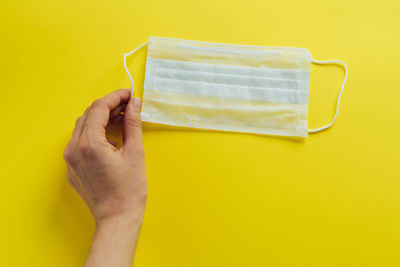 Close-up of hand holding yellow cup