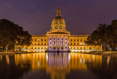 Reflection of illuminated building in water at night
