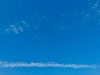 Low angle view of vapor trail in blue sky