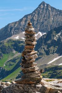 Stack of rocks on mountain against sky