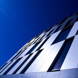 Low angle view of modern building against blue sky