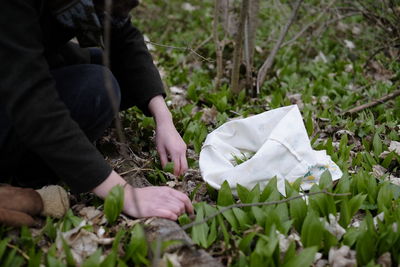 Midsection of woman holding flowers on field