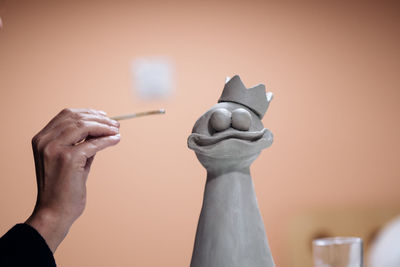 Cropped image of hand working on ceramic sculpture at workshop