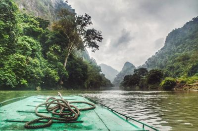 Scenic view of river by trees against sky