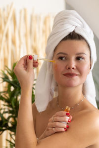 Close-up of young woman applying make-up