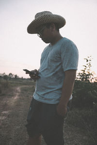 Full length of boy standing on field against sky