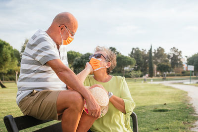 Couple of pensioners in love with mask in a park