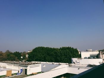 Houses in town against clear blue sky