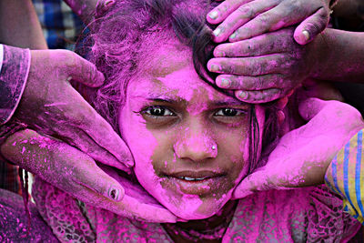 Cropped hands applying powder paints on woman face