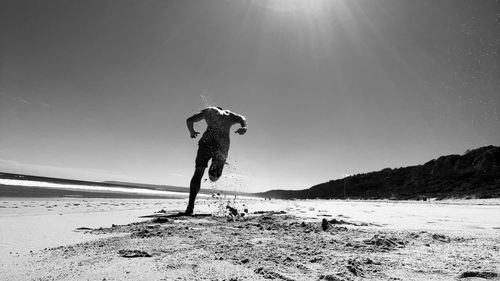Woman on beach against sky on sunny day