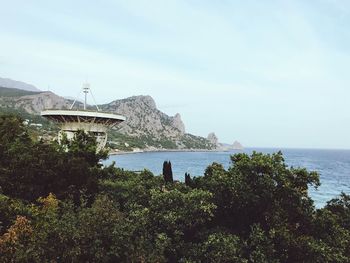 Scenic view of sea by buildings against sky