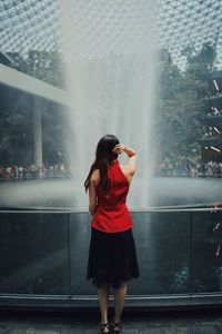 Rear view of woman standing by fountain outdoors