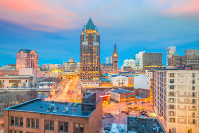 Buildings in city against cloudy sky