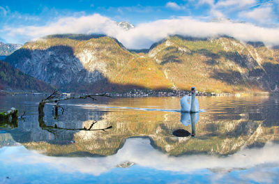 Scenic view of lake by mountain against sky