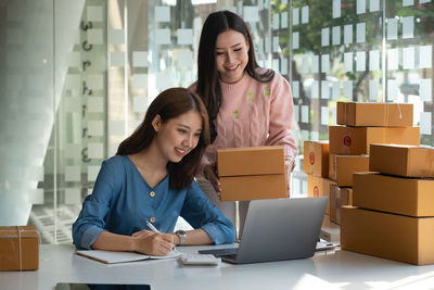 Happy businesswoman with colleague working in store