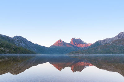 Cradle mountain on sunrise reflected on mirror like lake dove water with subtle mist
