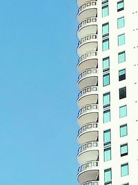 Low angle view of modern building against clear blue sky