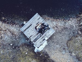 Directly above view of young couple lying on floorboard at riverbank