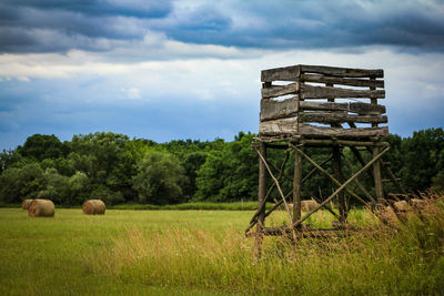 Hay bales on field against sky