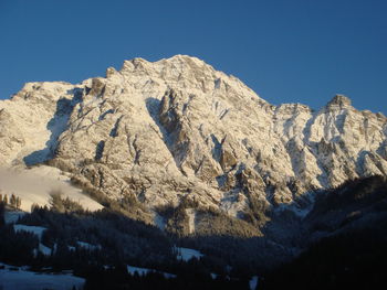 Scenic view of snowcapped mountains against clear blue sky