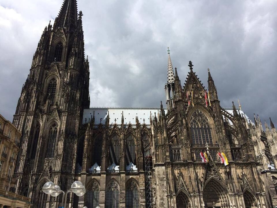 architecture, place of worship, religion, building exterior, built structure, spirituality, church, sky, cathedral, low angle view, cloud - sky, history, famous place, cloudy, travel destinations, cloud, steeple, temple - building