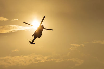 Low angle view of silhouette airplane against sky during sunset