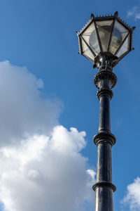 Low angle view of street light against cloudy sky