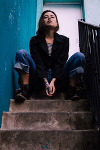 Young woman sitting on staircase