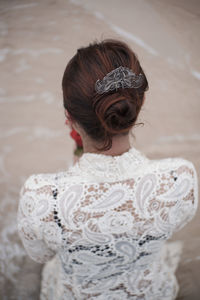 Rear view of woman standing against white wall