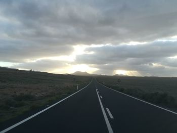 Empty road along landscape against sky