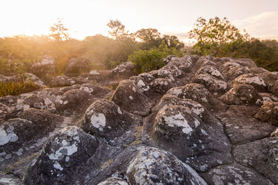 Rocks on land against sky during sunset