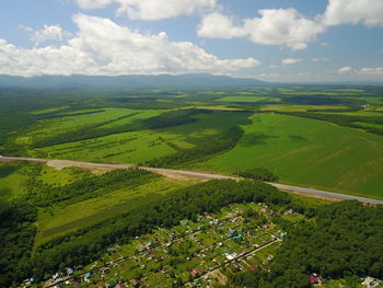 High angle view of green landscape against sky