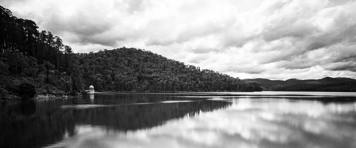 Scenic view of lake by trees against sky