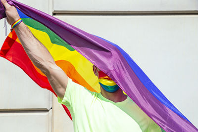 Portrait of man with flag on head, mask and gay bracelet