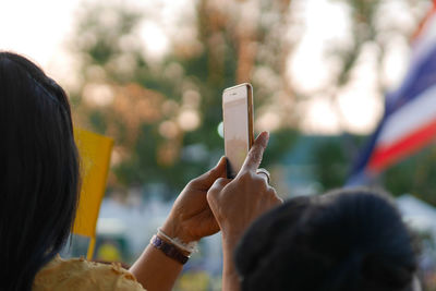 Woman photographing with smart phone outdoors