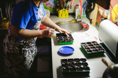 Midsection of woman preparing chocolates at home