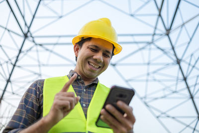 Portrait of smiling man holding mobile phone