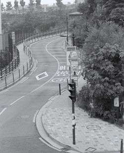 Road sign by trees on street in city