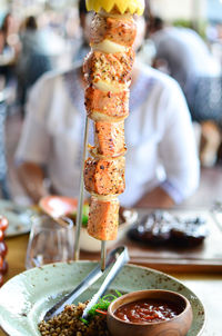 Close-up of grilled meat in skewer at restaurant table