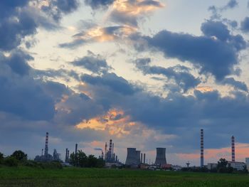 Panoramic view of factory against sky during sunset