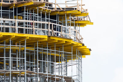 Low angle view of yellow construction site against sky